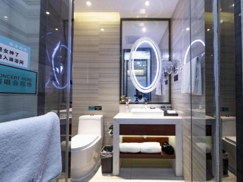 a bathroom with a sink and a toilet and a mirror at Xana Hotelle Xi'an GONG IP South Gate of Zhonglou in Xi'an