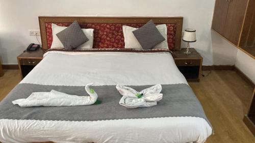 a bedroom with a bed with two towels on it at The Kurja Garden in Leh