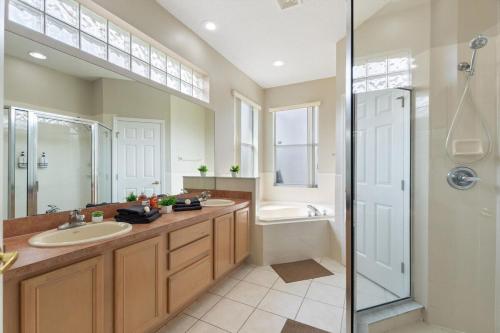 a bathroom with two sinks and a shower at Chic 4BR,Heated Pool,Jacuzzi & Dining Oasis near Disney & Legoland in Haines City