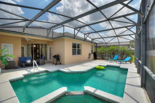 a swimming pool with a glass roof over a house at Chic 4BR,Heated Pool,Jacuzzi & Dining Oasis near Disney & Legoland in Haines City