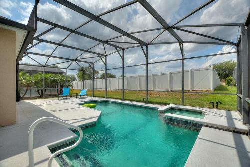 a swimming pool with a metal canopy over it at Chic 4BR,Heated Pool,Jacuzzi & Dining Oasis near Disney & Legoland in Haines City