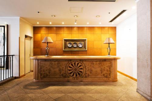 a lobby with a reception desk with two lamps at Hotel Allamanda Aoyama Tokyo in Tokyo