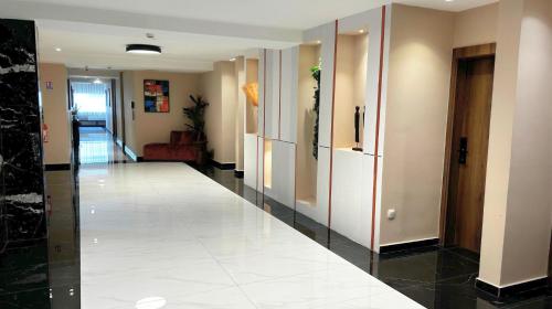 a hallway of a building with a white tile floor at Hôtel Ivotel Abidjan in Abidjan