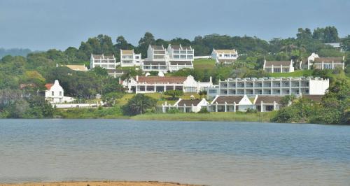 a group of houses on a hill next to a body of water at The Estuary Hotel & Spa in Port Edward