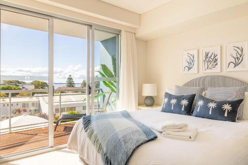 a bedroom with a bed with a view of the ocean at Cote D'Azur 42, 61 Donald St - complex pool, lift, linen, bed making and stunning water views in Nelson Bay
