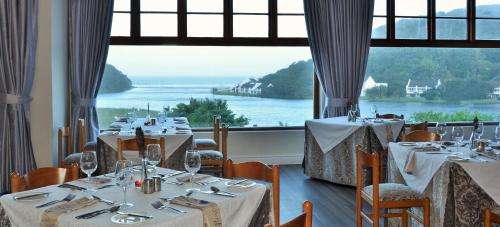 a dining room with tables and a large window at The Estuary Hotel & Spa in Port Edward