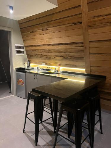 a kitchen with a black table and some stools at Orion, Hills of Zaarour in Zaarour