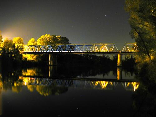 a bridge over a river at night at Hotel Kristall in San Donà di Piave