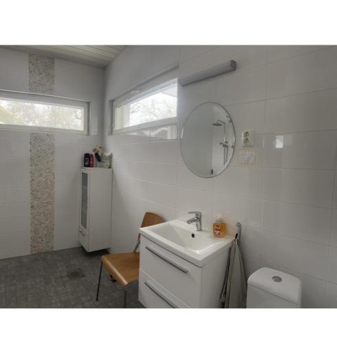 a bathroom with a sink and a toilet and a mirror at Lomamökki 25 km Turusta in Masku