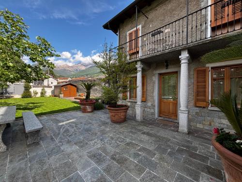 a patio with a bench and a house at Garden's Lodge - Larihome A79 in Gravedona