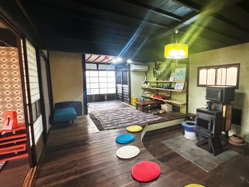 a living room with a table with frisbees on the floor at 古民家一棟貸しナノビレッジ岡山 in Kaga