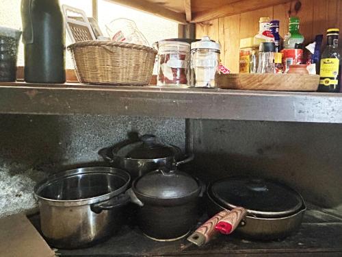 a kitchen with pots and pans on a stove at 古民家一棟貸しナノビレッジ岡山 in Kaga