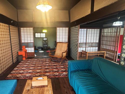 a living room with a couch and a rug at 古民家一棟貸しナノビレッジ岡山 in Kaga