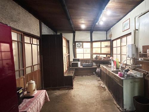 a kitchen with a sink and a counter top at 古民家一棟貸しナノビレッジ岡山 in Kaga