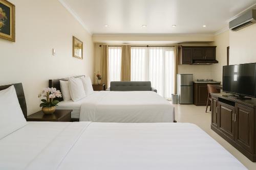 a hotel room with two beds and a television at La Bonita - Phu My Hung in Ho Chi Minh City