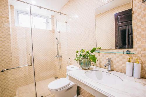 een badkamer met een toilet, een wastafel en een douche bij Villa NT119 FLC Sầm Sơn in Sầm Sơn