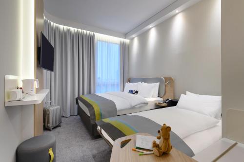 a hotel room with two beds and a tv at Holiday Inn Express - Regensburg by IHG in Regensburg