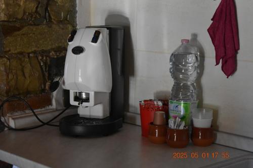 un mixer bianco appoggiato su un bancone accanto a una bottiglia d'acqua di Rabat home a Tursi