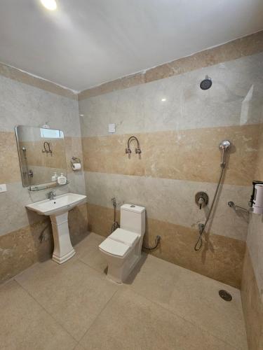 a bathroom with a toilet and a sink and a shower at Snow Range Retreat in Manāli