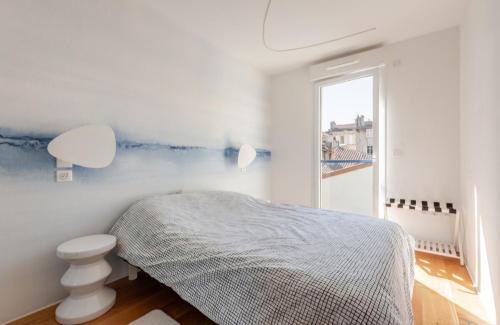 a white bedroom with a bed and a window at Casa de Marseille in Marseille