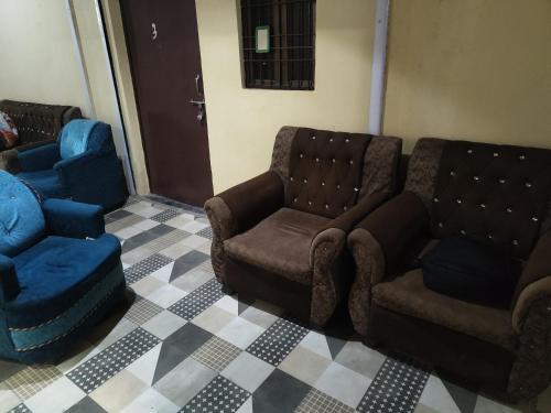 a living room with a couch and a chair at Jhusi Hotel & Restaurant in Jhūsi