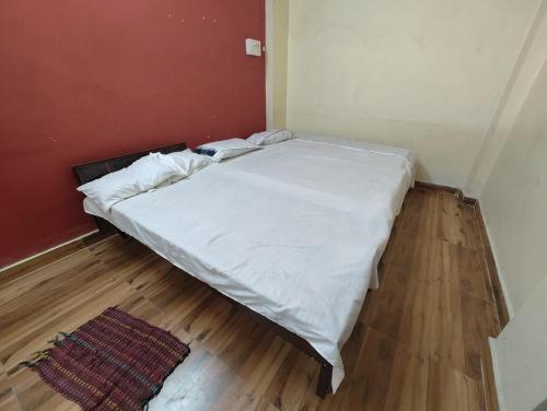 a large bed in a room with a wooden floor at Jhusi Hotel & Restaurant in Jhūsi