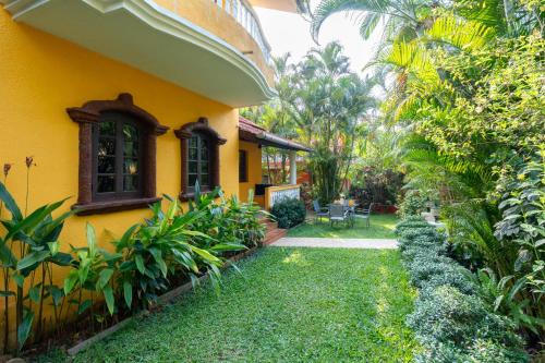 a yellow house with a garden in front of it at Beachside Bliss Villas Candolim 10 min walk from Sinquerim Beach in Sinquerim