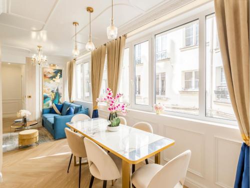 une salle à manger avec une table, des chaises et un canapé dans l'établissement Merveil - Luxury Suite - Marais - Poissonniere, à Paris