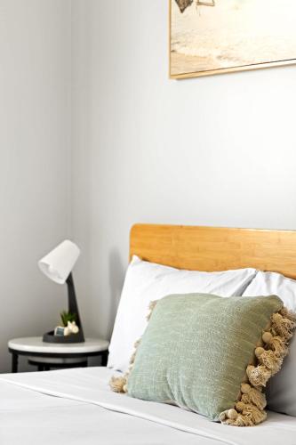 a bed with a green pillow on top of it at Live in Comfort - Ensuite Double Room in the Heart of Belmore in Sydney