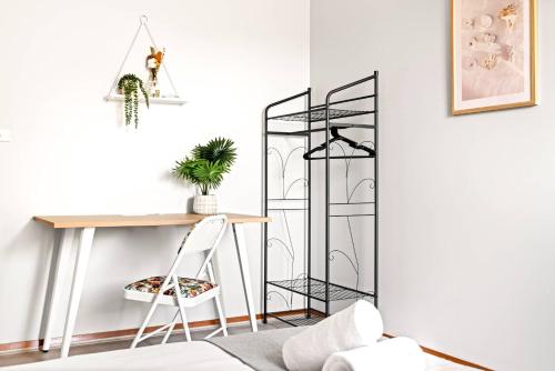 シドニーにあるLive in Comfort - Ensuite Double Room in the Heart of Belmoreのテーブルの横に椅子とデスクが備わる客室です。