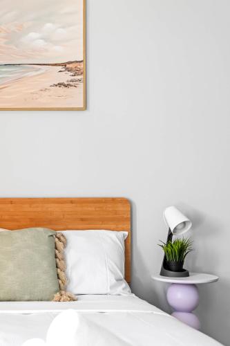 a bedroom with a bed with a lamp and a picture at Live in Comfort - Ensuite Double Room in the Heart of Belmore in Sydney