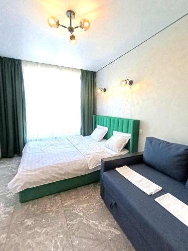 a bedroom with a bed and a couch at Апартаменти Ашан Автовокзал Стрийська in Lviv