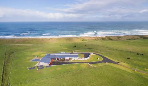 an aerial view of a farm with the ocean at house by the sea in Warrnambool