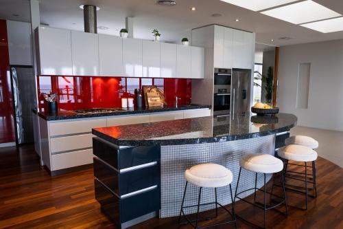 a kitchen with a counter with stools around it at house by the sea in Warrnambool