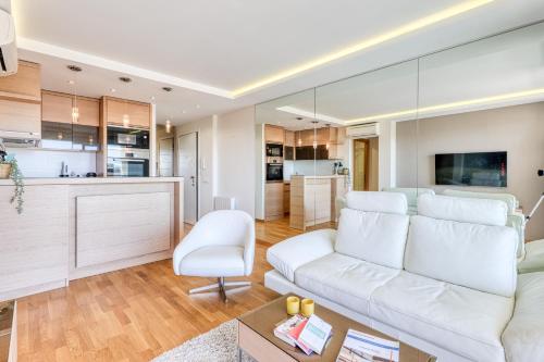 un salon avec un canapé blanc et une cuisine dans l'établissement Port Azur Sea View - Happy Rentals, au Golfe-Juan