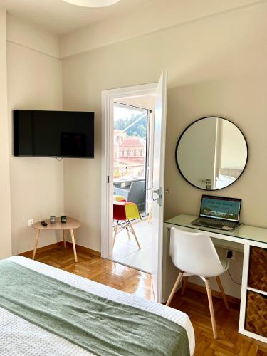 a bedroom with a bed and a desk with a laptop at KK Athens Fine Stay-Steps to Metro-Modern & Cozy Apartments in Athens
