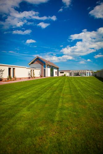 a large grass field in front of a building at Rodizio Hill Resort in Cluj-Napoca