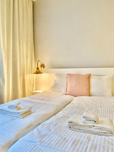 a white bed with two towels on top of it at Katas Suite, Helsinki city center in Helsinki