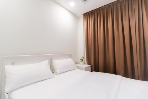 a bedroom with a white bed and brown curtains at Sunrise Stay 202 Comfy Modern Room in Hulhumale by the Beach in Hulhumale