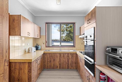 シドニーにあるComfortable Single Room in Convenient Belmore Location - Shared Bathroomのキッチン(木製キャビネット付)、窓