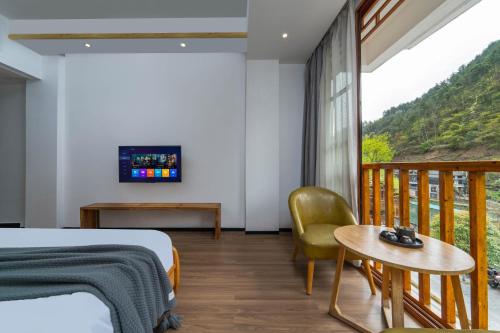 a bedroom with a bed and a balcony at Phoenix Mandu River View Homestay in Fenghuang