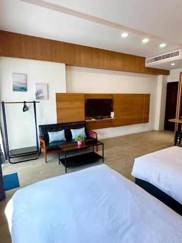 a hotel room with two beds and a flat screen tv at Slowly inn in Hengchun