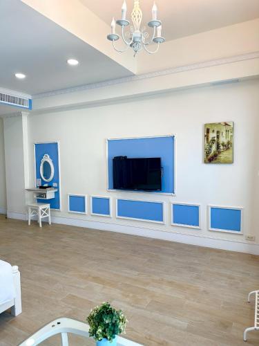 a large room with blue and white walls and a flat screen tv at Slowly inn in Hengchun