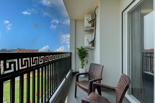 a balcony with two chairs and a view of the city at The Lodgers 1 BHK Serviced Apartments Near Artemis Hospital Sector 52 in Gurgaon