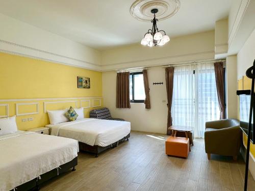 a hotel room with two beds and a couch at Slowly inn in Hengchun