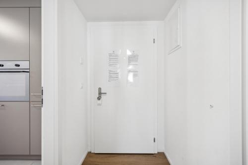 a white kitchen with a white door in a room at UP&GREAT Apartments - Stylish City Living in Zürich