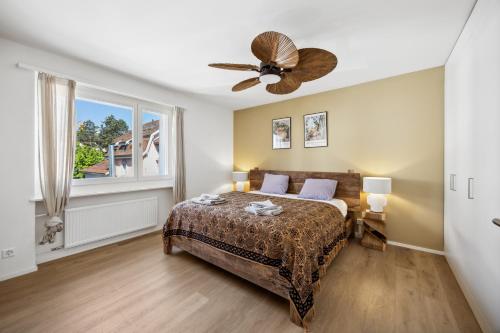 a bedroom with a bed and a ceiling fan at UP&GREAT Apartments - Stylish City Living in Zürich