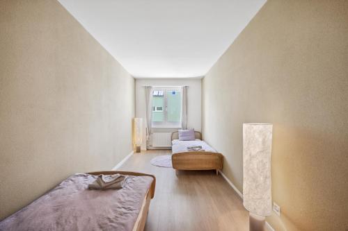 a small room with two beds and a lamp at UP&GREAT Apartments - Stylish City Living in Zürich