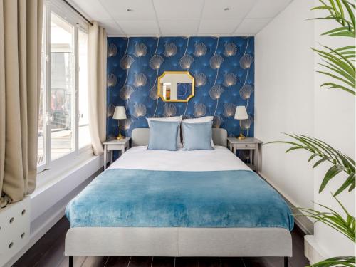 une chambre avec un lit avec un mur bleu dans l'établissement Merveil - Family suite - Louvre - Victoires, à Paris