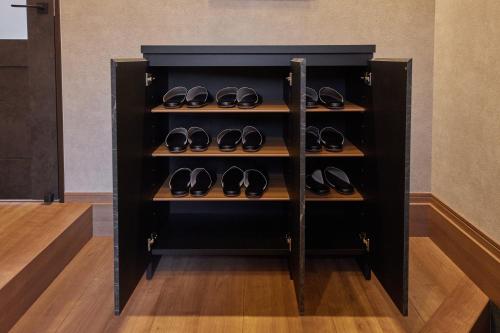 a black shelf with pairs of shoes on it at By The BIWAKO in Takashima